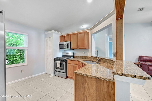 kitchen featuring kitchen peninsula, stainless steel appliances, sink, and light stone countertops