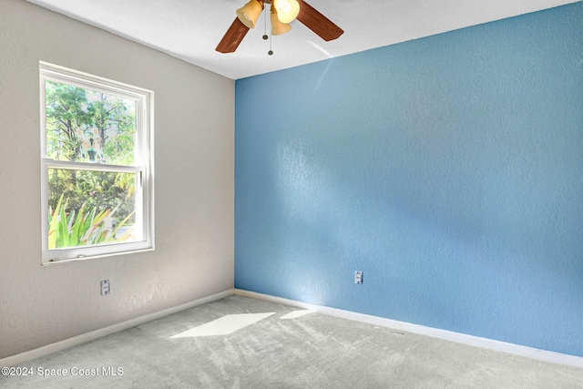 carpeted empty room featuring ceiling fan