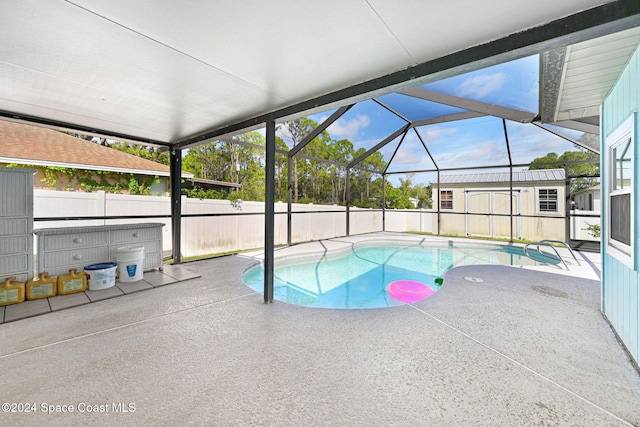 view of pool featuring glass enclosure, an outdoor structure, and a patio area