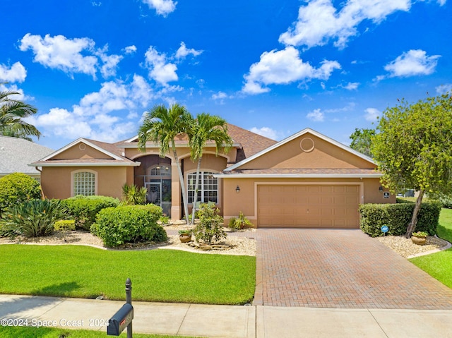 ranch-style house with a garage and a front yard