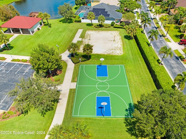 view of basketball court featuring a yard and a water view