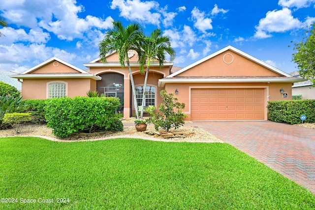 single story home featuring a garage and a front lawn