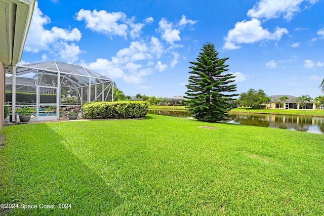 view of yard with glass enclosure and a water view