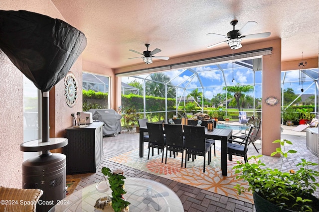 view of patio / terrace featuring ceiling fan, grilling area, and a lanai