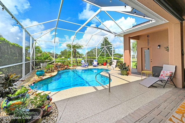 view of swimming pool featuring glass enclosure and a patio area