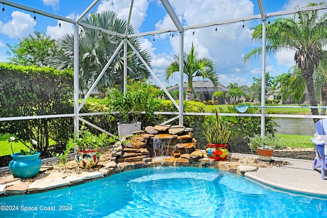 view of swimming pool with glass enclosure and pool water feature