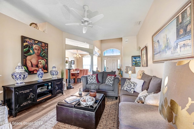 living room featuring ceiling fan with notable chandelier and hardwood / wood-style flooring