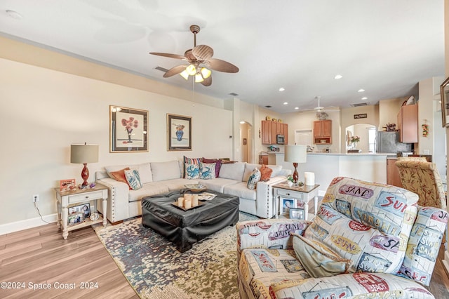 living room featuring light hardwood / wood-style flooring and ceiling fan