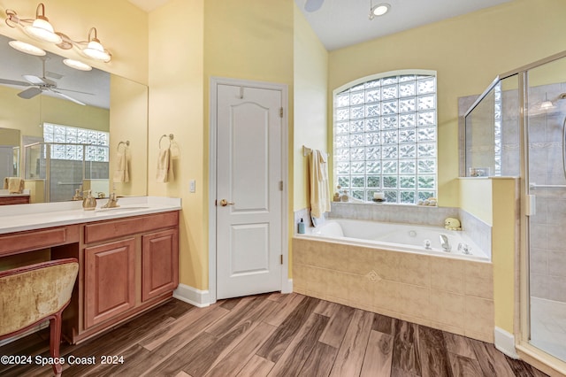 bathroom featuring ceiling fan, a wealth of natural light, shower with separate bathtub, and vanity