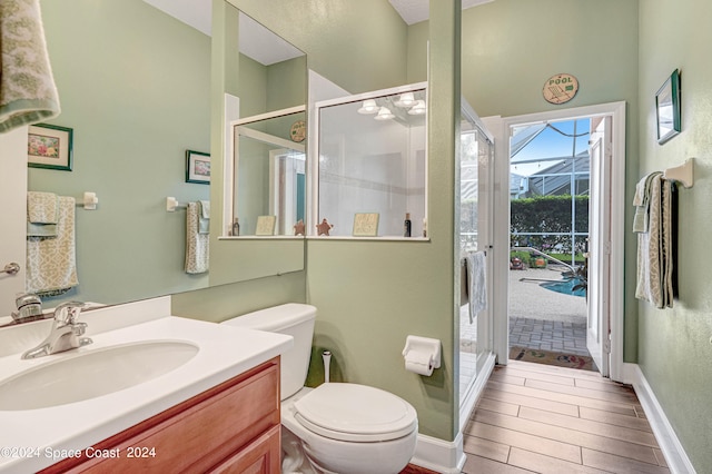 bathroom with a wealth of natural light, a shower with door, toilet, and vanity