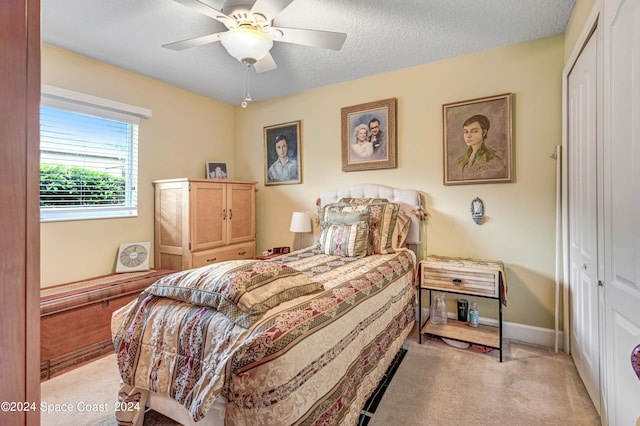 carpeted bedroom with a textured ceiling, a closet, and ceiling fan