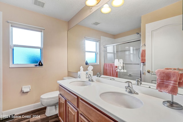 bathroom featuring toilet, hardwood / wood-style flooring, a healthy amount of sunlight, and vanity