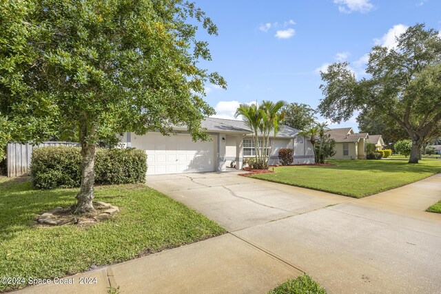 view of front of property with a front lawn and a garage