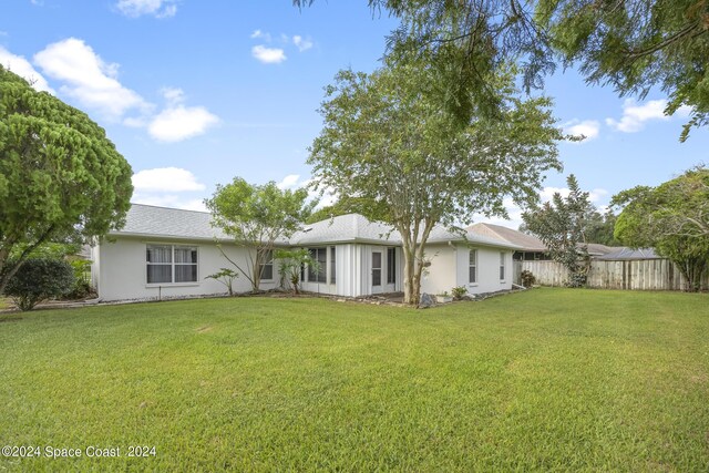 rear view of property featuring a lawn