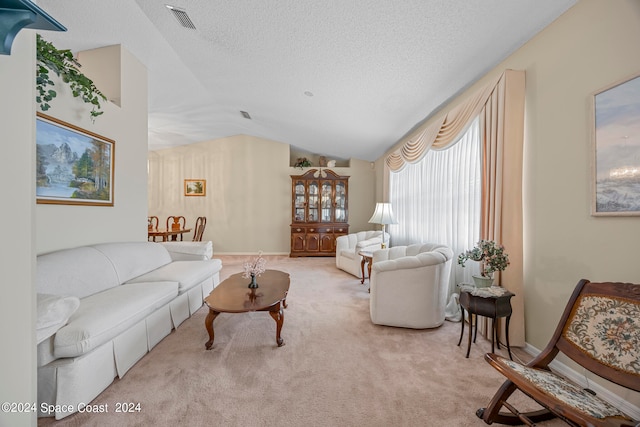 living room featuring a textured ceiling, light carpet, and lofted ceiling