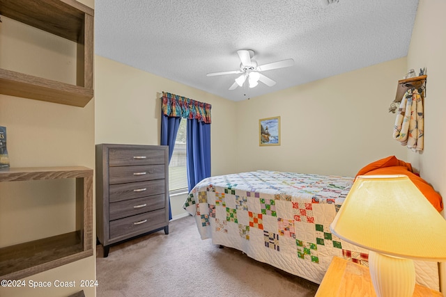 bedroom with a textured ceiling, carpet flooring, and ceiling fan