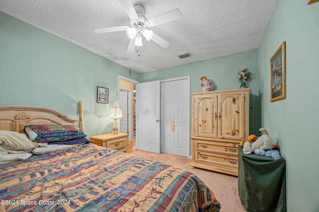 carpeted bedroom featuring ceiling fan, a closet, and a textured ceiling