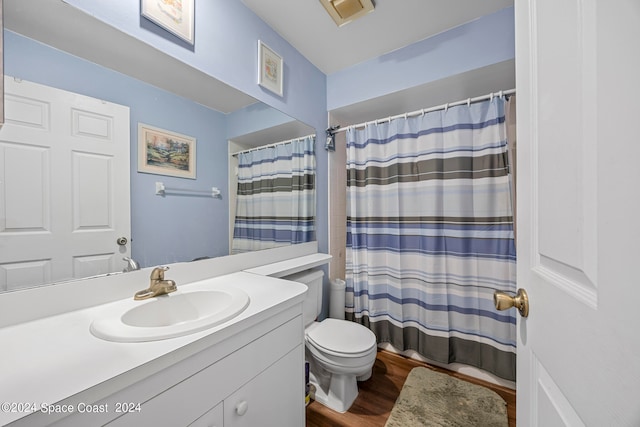 bathroom with toilet, vanity, and wood-type flooring