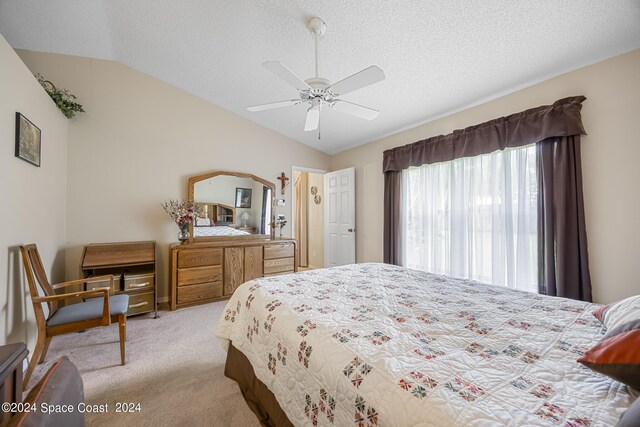 carpeted bedroom with ceiling fan, a textured ceiling, and lofted ceiling