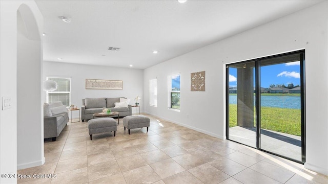 living room featuring light tile patterned floors and a water view