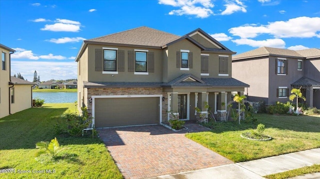 view of front of house featuring covered porch, a water view, a garage, and a front lawn