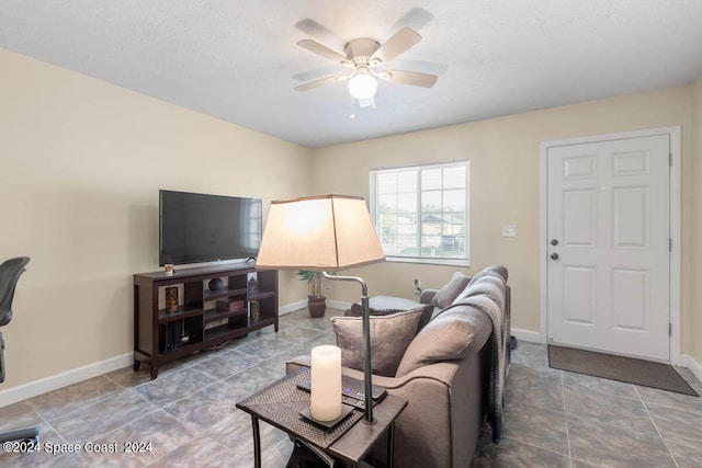 living room featuring ceiling fan and tile patterned flooring