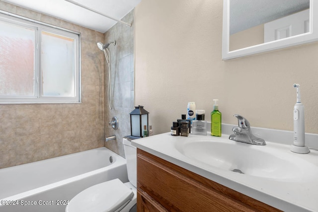 full bathroom with tiled shower / bath, toilet, and vanity