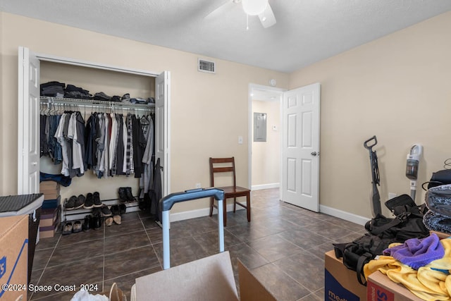 bedroom with ceiling fan, a closet, and dark tile patterned floors