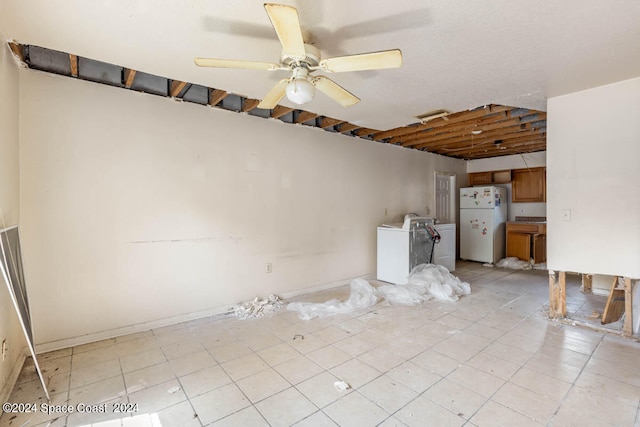 unfurnished living room featuring ceiling fan, light tile patterned floors, and washer and dryer