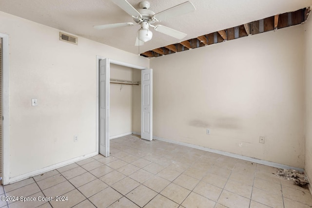 unfurnished bedroom with ceiling fan, a closet, and light tile patterned floors