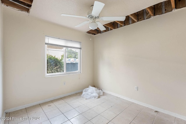 empty room with ceiling fan and light tile patterned floors