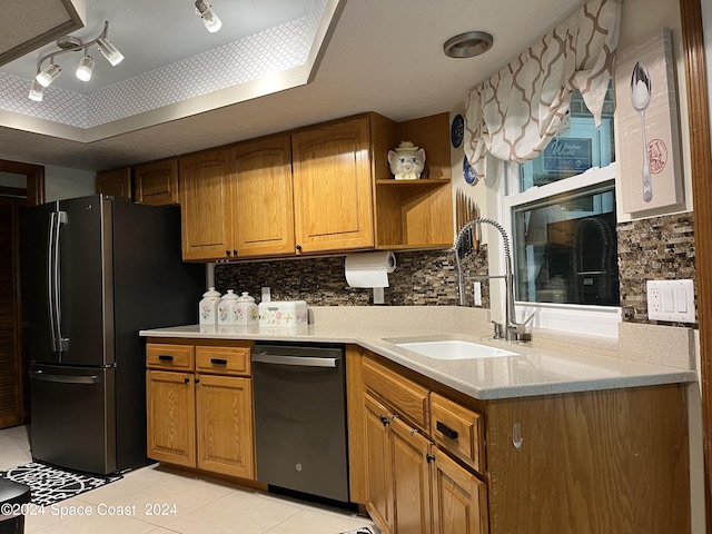 kitchen featuring sink, light tile patterned floors, stainless steel fridge, dishwasher, and backsplash