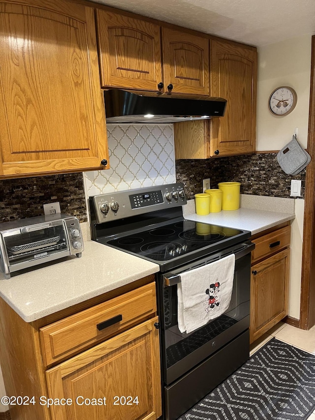 kitchen featuring electric stove and backsplash