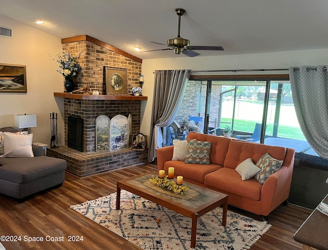 living room with hardwood / wood-style floors, vaulted ceiling, and a brick fireplace