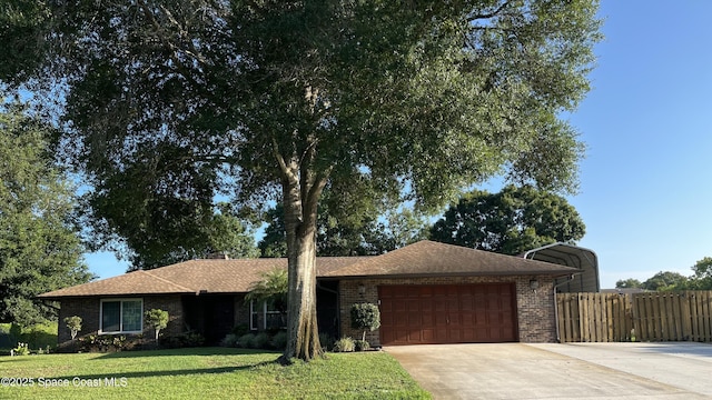 ranch-style home featuring a carport, a garage, and a front lawn