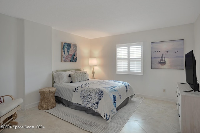 bedroom featuring light tile patterned floors and baseboards