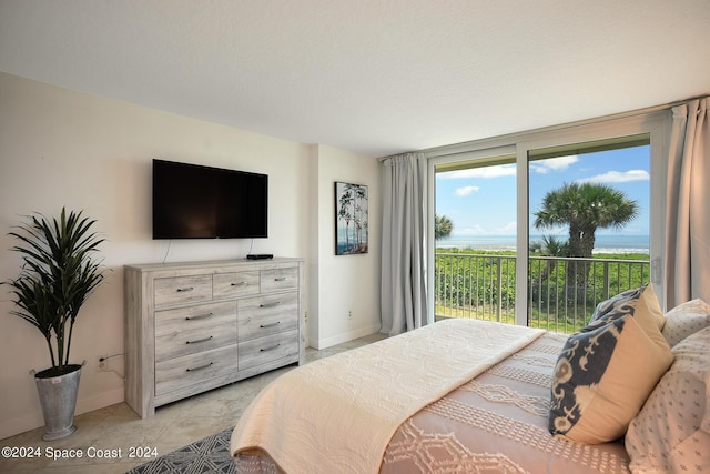 bedroom featuring expansive windows, access to outside, light tile patterned flooring, and baseboards