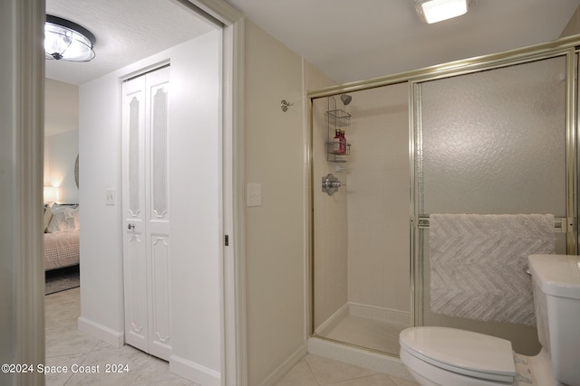 bathroom with tile patterned flooring, toilet, and walk in shower