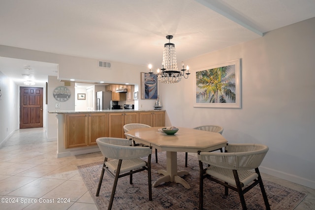 dining area with light tile patterned floors, baseboards, visible vents, and an inviting chandelier