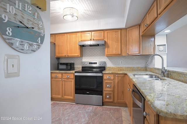 kitchen with a notable chandelier, stainless steel appliances, sink, kitchen peninsula, and light stone counters