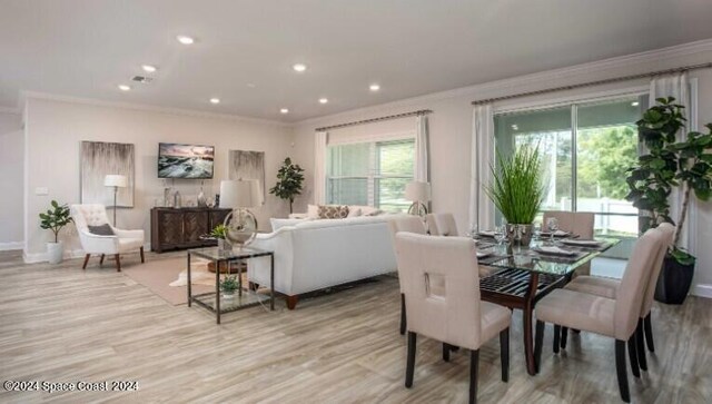 dining space with a wealth of natural light, light wood-type flooring, and ornamental molding