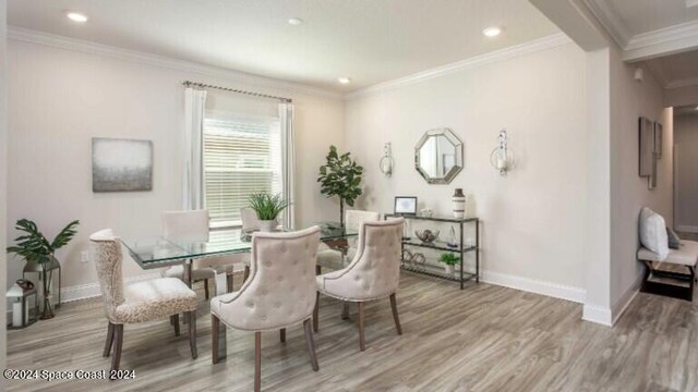 dining room with light wood-type flooring and ornamental molding