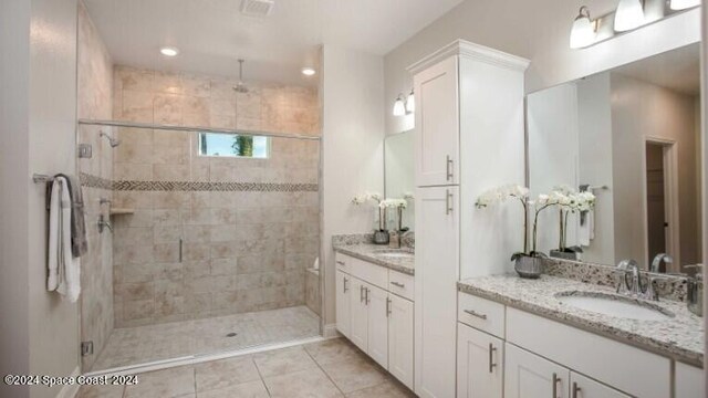 bathroom featuring tile patterned flooring, vanity, and walk in shower