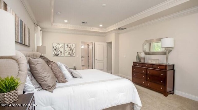 carpeted bedroom featuring a tray ceiling, ensuite bath, and ornamental molding