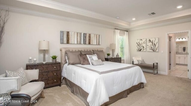 bedroom with crown molding, light colored carpet, a tray ceiling, and ensuite bath