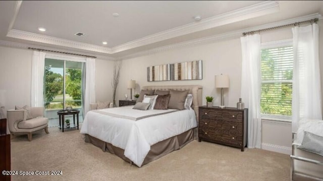 bedroom featuring light carpet, a tray ceiling, and ornamental molding