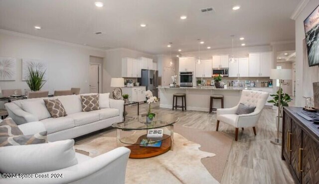 living room with light hardwood / wood-style floors and ornamental molding