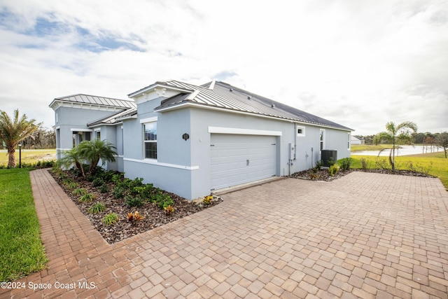 view of side of home featuring a garage and central air condition unit