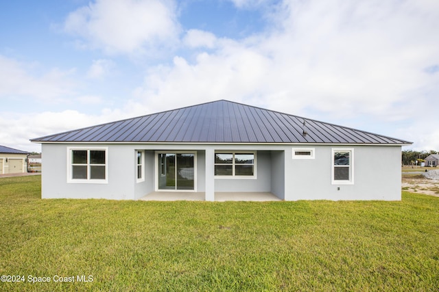 rear view of property featuring a lawn and a patio