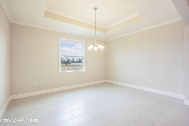 tiled empty room featuring an inviting chandelier, a raised ceiling, and crown molding